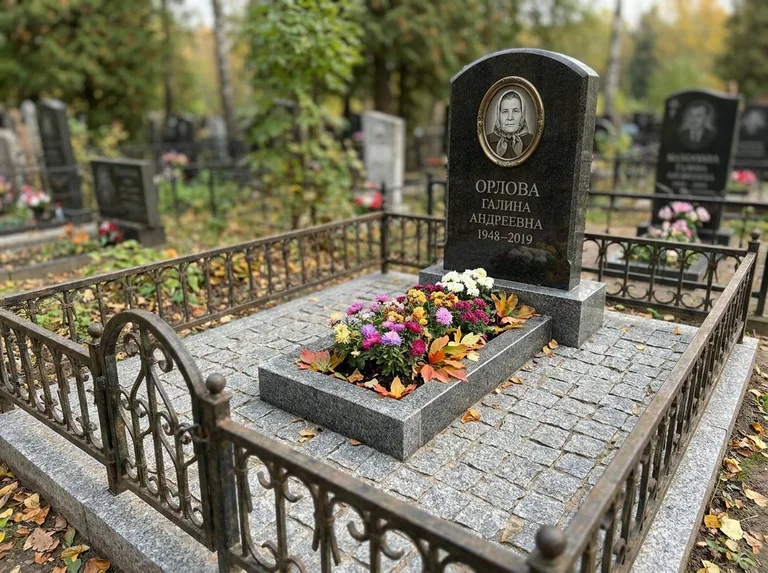 Благоустроенное захоронение с гранитной плиткой, оградой и цветником в Ростове-на-Дону