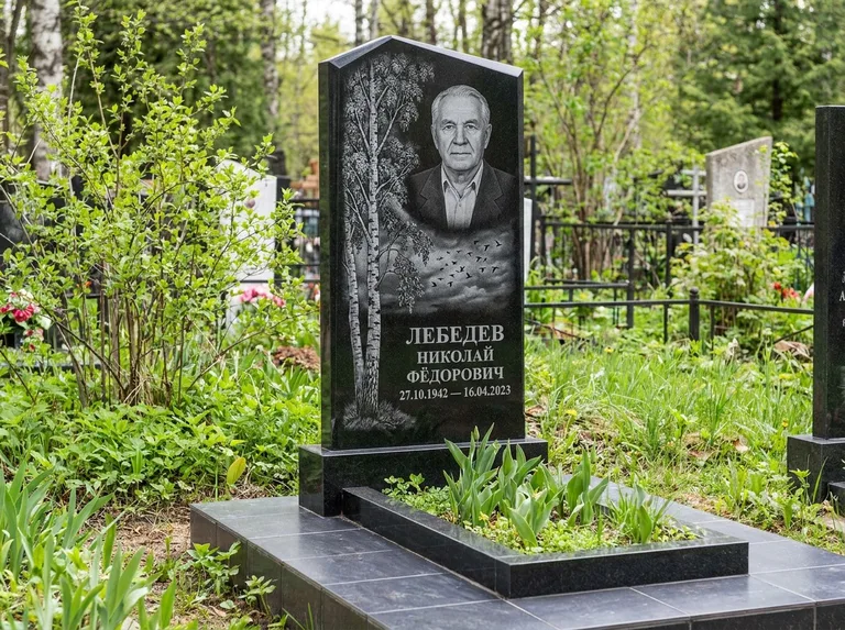 Памятник с гравировкой берёзы: вертикальная стела со скошенным верхом — берёза и стая птиц в небе, гранитный цоколь с тёмной плиткой, работа «Лебедев» в Ростове-на-Дону