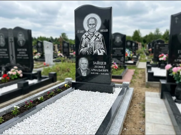 Памятник с гравировкой иконы: стела с крестообразным навершием — икона в резной рамке-киоте, газон без ограды, стриженая трава, работа «Раевская» в Ростове-на-Дону