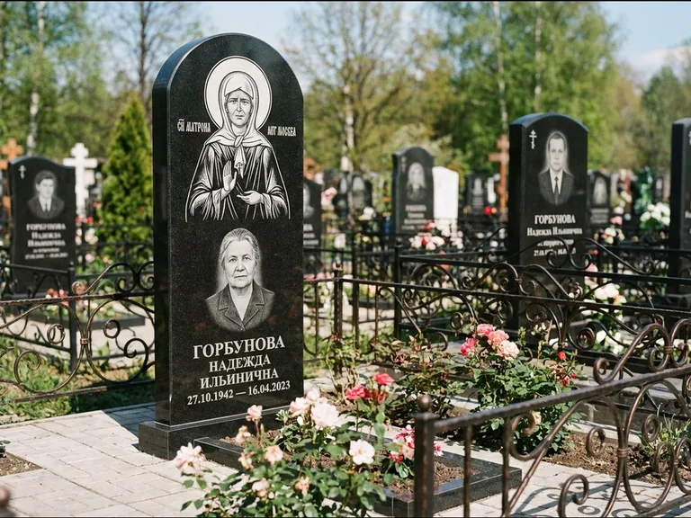 Памятник с гравировкой иконы: стела с арочным верхом и киотом под образ — гравировка образа Матроны Московской, гранитный цоколь с тёмной плиткой, работа «Ковалёв» в Ростове-на-Дону