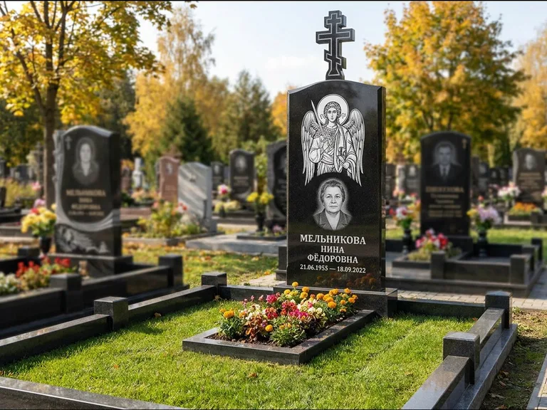 Памятник с гравировкой иконы: округлая стела-медальон с ликом — гравировка Богородицы «Семистрельная», луговые травы и полевые цветы за участком, работа «Гущин» в Ростове-на-Дону