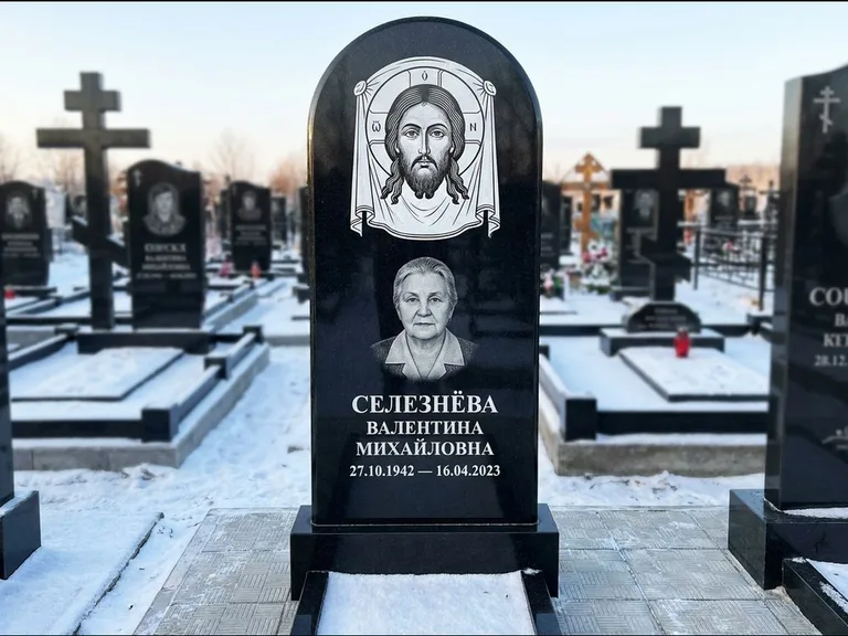 Памятник с гравировкой иконы: небольшая скромная одиночная стела с именной иконой — золочёный нимб на образе, аккуратный участок с газоном, работа «Ковалёв» в Ростове-на-Дону