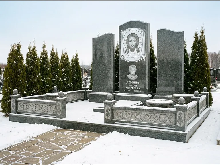 Памятник с гравировкой иконы: узкая вертикальная стела-пилон с ликом — икона в резной рамке-киоте, открытая лужайка без ограды, работа «Одинцов» в Ростове-на-Дону