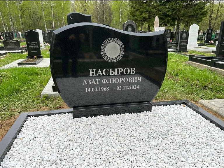 Мусульманский памятник: стела с волнообразным скошенным верхом — гравировка мечети под полумесяцем и звёздами, белая мраморная крошка с бордюром, работа «Насыров» в Ростове-на-Дону