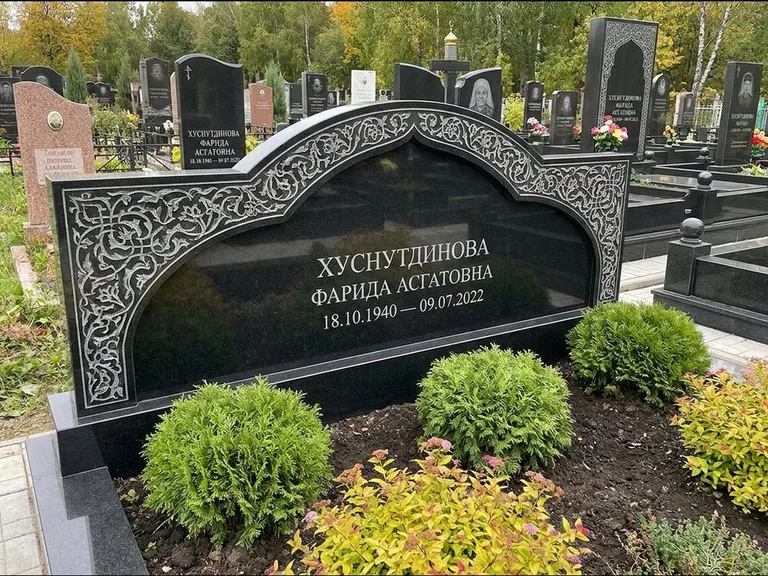Мусульманский памятник: вытянутая горизонтальная семейная стела с аркой — белая гравировка силуэта мечети с минаретами, участок с декоративными кустами, работа «Зарипова» в Ростове-на-Дону