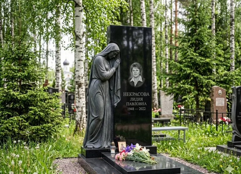 Гранитная фигура скорбящего мужчины у чёрной стелы в Ростове-на-Дону