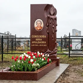 Мемориал с зажженной свечой из красного гранита