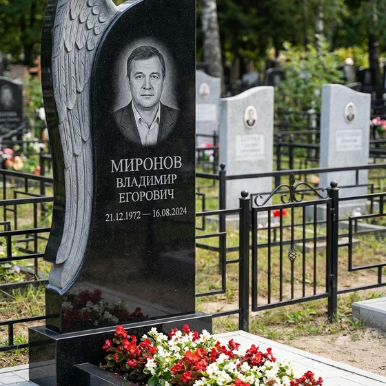 Мемориал с обнимающим крылом ангела из черного габбро-диабаза