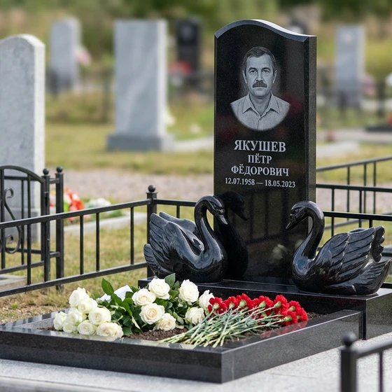 Памятник с парой лебедей из габбро-диабаза с портретом